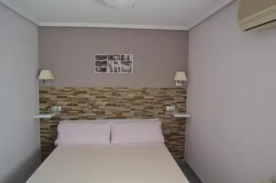 a bedroom with a bed and a brick wall at Hostal La Pilarica in Paterna