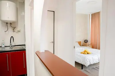 a room with a bed and a kitchen with a mirror at Renovado y sofisticado en el centro de Valencia in Valencia