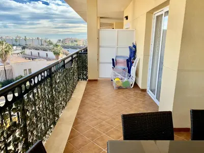 a balcony with a chair and a view of the city at Urbanización Mar de Canet, 2 dormitorios con piscina comunitaria, garaje y wifi in Canet de Berenguer