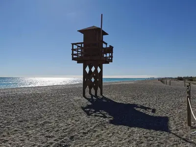 a lifeguard tower on a sandy beach near the ocean at Global Vacacional, Apartamento en Marjal de Corinto con Piscina in Sagunto