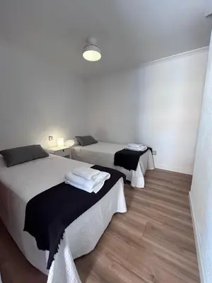 a bedroom with two beds and a table with towels at Lovely 3-Bedroom Apartment 15 Minutes from Beach in Valencia