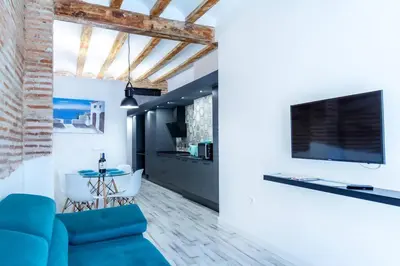 a living room with a blue couch and a flat screen tv at Chic estudio privado al lado de la playa in Valencia