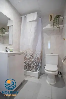 a bathroom with a toilet and a shower curtain at Front Sun Beach Apartment in Valencia