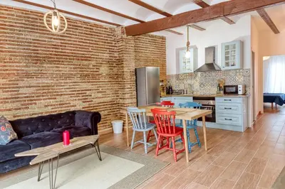 a kitchen and living room with a brick wall at Beams & Bricks in Valencia