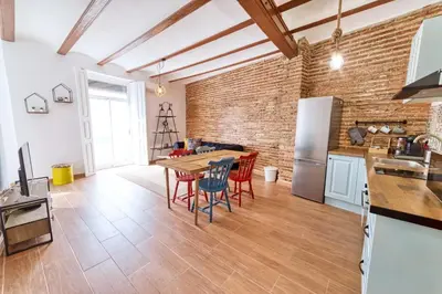 a kitchen with a table and chairs and a brick wall at Beams & Bricks in Valencia