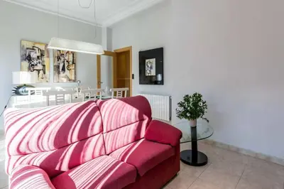 a living room with a red couch and a table at PRECIOSO APARTAMENTO EN EL BARRIO DE RUZAFA in Valencia
