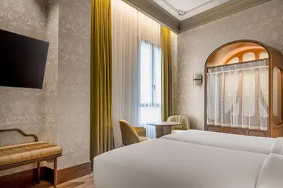 a hotel room with a white bed and a window at Palacio Santa Clara, Autograph Collection in Valencia