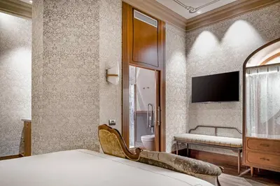 a bedroom with a bed and a tv on a wall at Palacio Santa Clara, Autograph Collection in Valencia