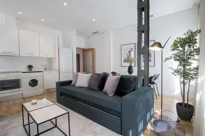 a living room with a blue couch and a table at Apartamentos San Vicente in Valencia