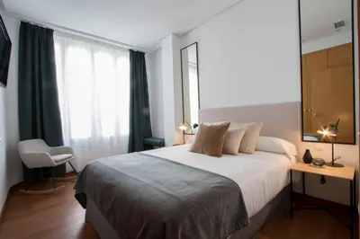 a bedroom with a large bed and a window at Apartamentos San Vicente in Valencia