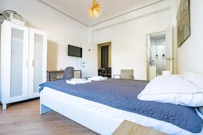 a bedroom with a bed and a desk and a television at Jardín Botánico Rooms in Valencia