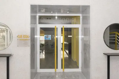 a glass door with yellow handles in a building at Florazar 3, 8º-B in Cullera