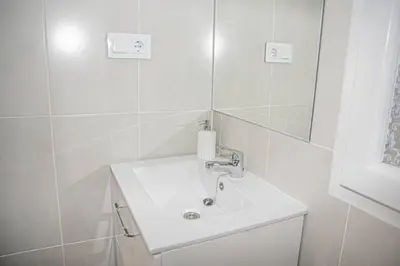 a white bathroom with a sink and a mirror at Lovely Modern Flat Valencia center in Valencia