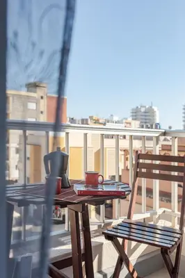 a table and a chair on a balcony at Hostal El Perelló, Valencia in El Perelló
