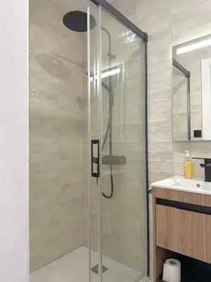 a shower with a glass door in a bathroom at Mercat Suites in Valencia