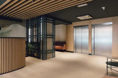 an office lobby with a glass elevator and a couch at Palau Suites & Apartments in Valencia