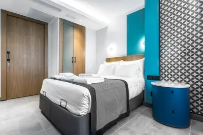 a bedroom with a large bed with a blue wall at PAMPHYLIA HOTEL in Valencia