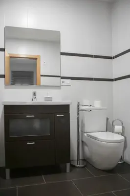 a bathroom with a toilet and a sink and a mirror at Natura Apartments in Chelva