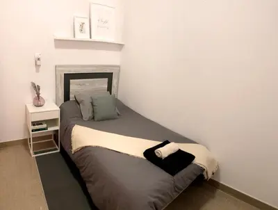a small bed in a room with a bedskirtspectspectspectspects at Natura Apartments in Chelva