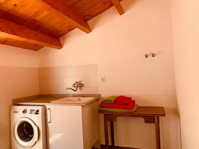 a laundry room with a sink and a washing machine at Casa del Herrero in Chulilla