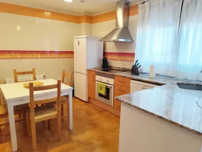 a kitchen with a table and a white refrigerator at Caudiel entre Sierras in Caudiel
