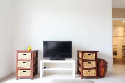 a living room with a tv and a white table at Global Vacacional, Estudio Cerca de la Playa, Pet-friendly in Canet de Berenguer