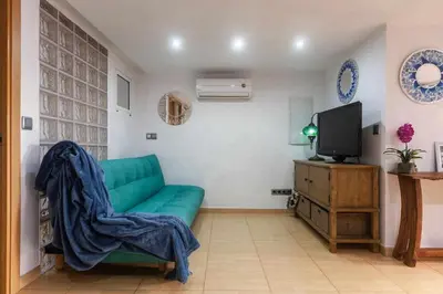 a living room with a green couch and a tv at Villa del Mar . in Puebla de Farnals
