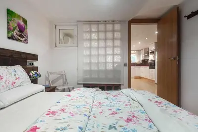a bedroom with a large bed and a kitchen at Villa del Mar . in Puebla de Farnals