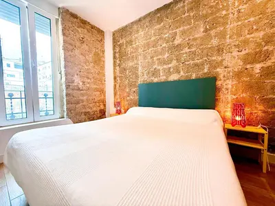 a bedroom with a white bed and a brick wall at Loft independiente con Piscina compartida en Centro de Valencia in Valencia