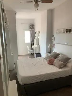 a bedroom with a large bed and a table at Apartamento primera línea de playa in Port Saplaya