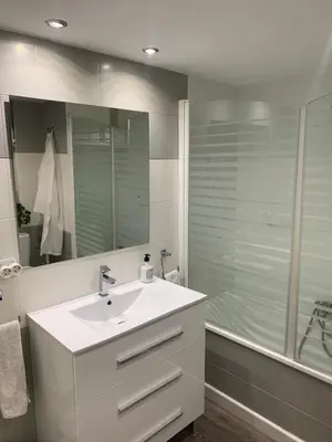 a white bathroom with a sink and a shower at Apartamento primera línea de playa in Port Saplaya