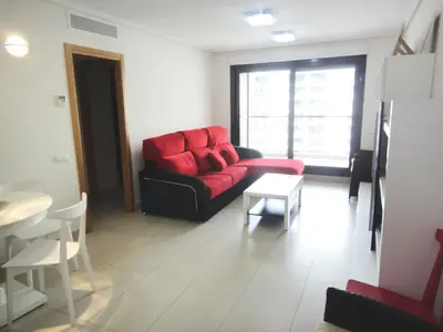 a living room with a red couch and a table at Patacona Beach Power!! in Valencia