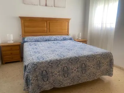 a bedroom with a bed with a blue comforter at Los Naranjos Solo Familias in Casas Las Basas