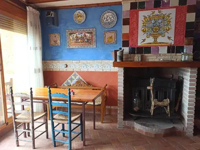 a dining room with a table and a fireplace at A la Sombra de la Torre in Serra