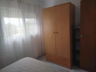 a bedroom with a closet and a wooden cabinet at Apartamento estudio en playa Puig in Valencia