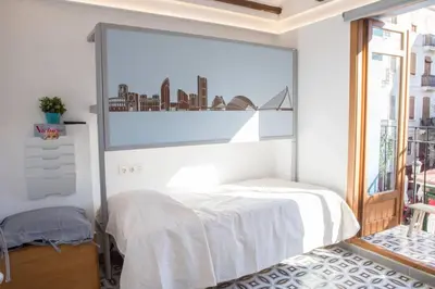a white bedroom with a large picture on the wall at Finca Reloj in Valencia