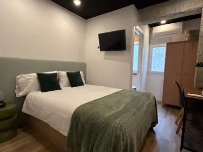 a bedroom with a bed and a tv on the wall at New Room in the beach in Valencia
