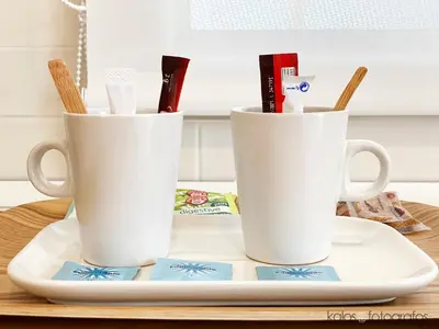 two white coffee mugs on a plate on a table at Increible ático con vistas al Mediterraneo by Hometels in Puerto de Sagunto