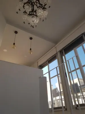 a room with a chandelier and a window at Increible ático con vistas al Mediterraneo by Hometels in Puerto de Sagunto