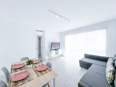a living room with a table and a couch at NUEVO, a 70 metros de la playa y con vistas al mar in Cullera