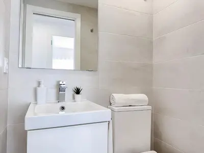 a white bathroom with a sink and a mirror at NUEVO, a 70 metros de la playa y con vistas al mar in Cullera