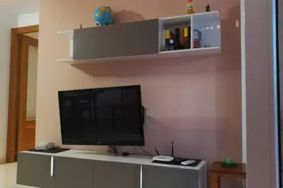 a flat screen tv sitting on top of a entertainment center at APARTAMENTOFAMILIAR, PLAYA, WIFI, PISCINA in Canet de Berenguer