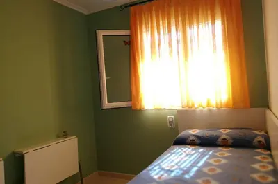 a bedroom with green walls and a bed with a window at APARTAMENTOFAMILIAR, PLAYA, WIFI, PISCINA in Canet de Berenguer