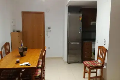 a kitchen with a wooden table and a refrigerator at APARTAMENTOFAMILIAR, PLAYA, WIFI, PISCINA in Canet de Berenguer