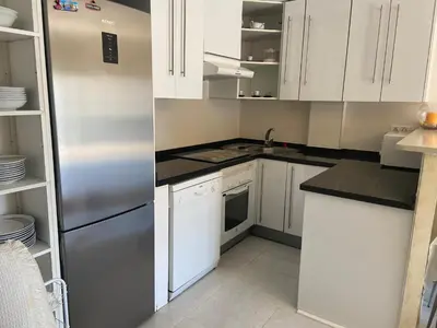 a kitchen with white cabinets and a stainless steel refrigerator at Atico playa Moncofar in Moncófar