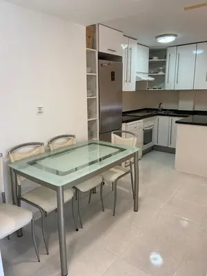 a kitchen with a glass table and chairs in it at Atico playa Moncofar in Moncófar