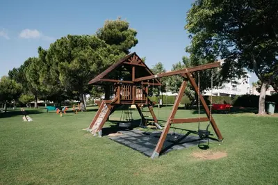 a playground with a wooden play structure in a park at Apartamento luminoso cerca del mar y la montaña in Puzol
