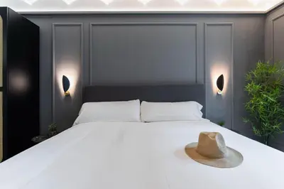 a bedroom with a bed with a hat on it at Reina 107 Beach Boutique in Valencia