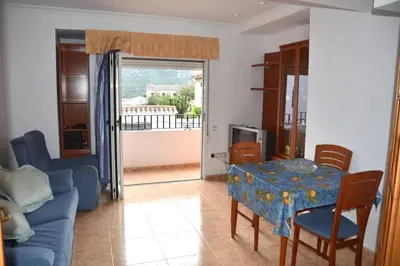 a living room with a blue couch and a table at APARTAMENTOS GALLACH (LA ERMITA) in Chulilla