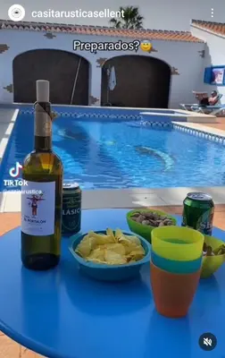a bottle of wine on a table next to a swimming pool at CASITA RUSTICA DE INVITADOS (NEXT TO XATIVA) in Sellent